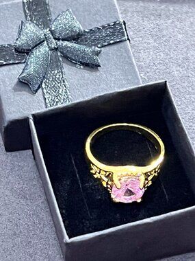 Beautiful vintage-style gold-tone ring featuring a round-cut pink stone with orn
